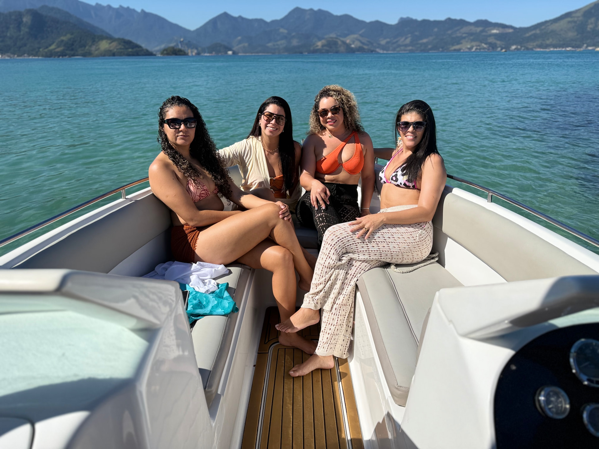 Amigos a bordo da lancha da Primares com as montanhas de Angra dos Reis ao fundo