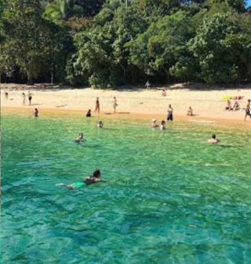 Praia do Araçá com areia clara, mar calmo e banhistas