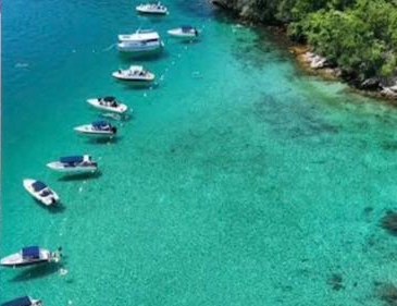 Lagoa Azul com águas transparentes e embarcações ancoradas